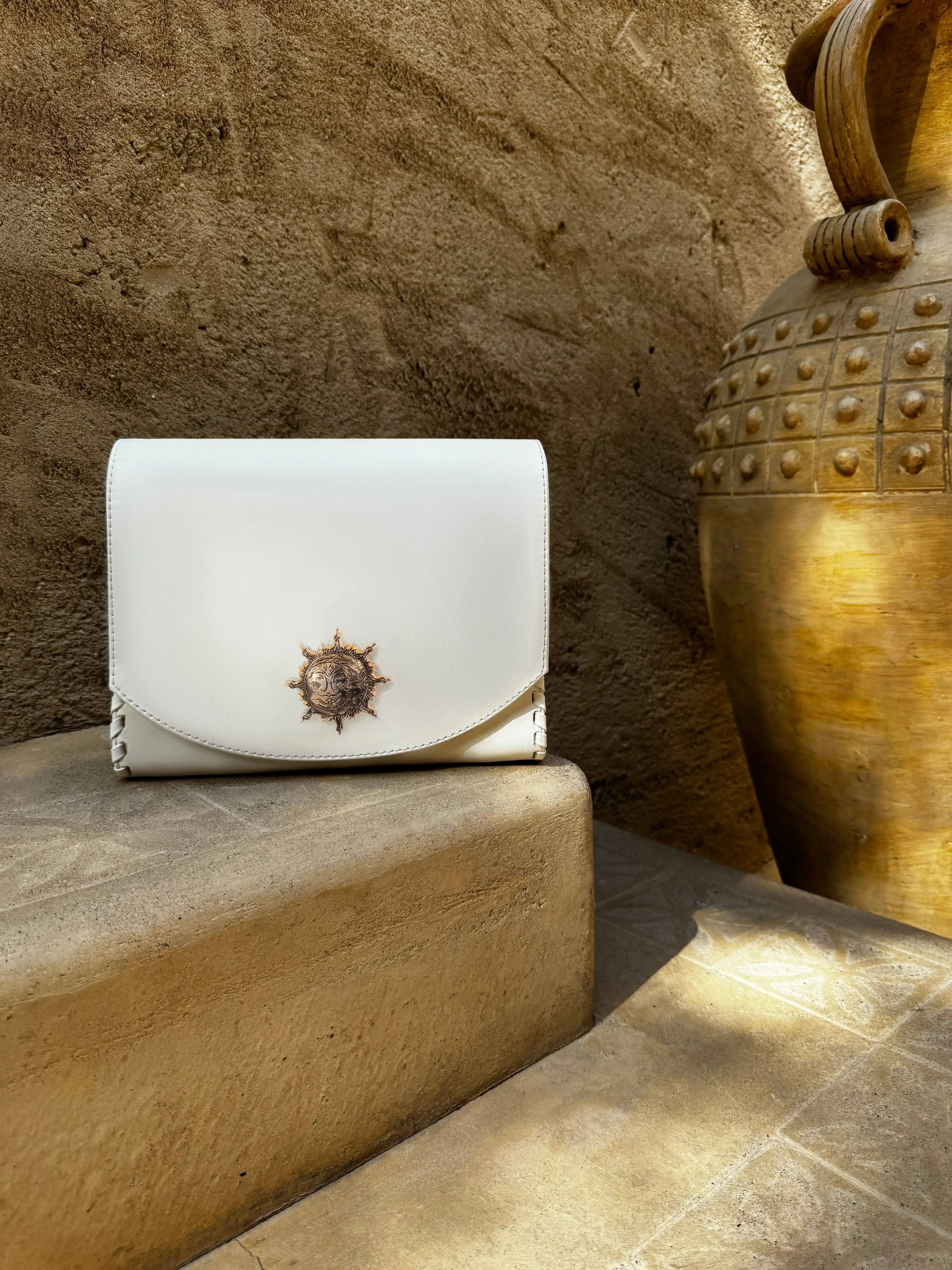 Sustainable KI'OLAL carry case crafted from cactus leather, displayed on golden-toned steps