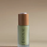 KI'OLAL Energizing Day Serum in green glass bottle with bamboo cap on neutral backdrop