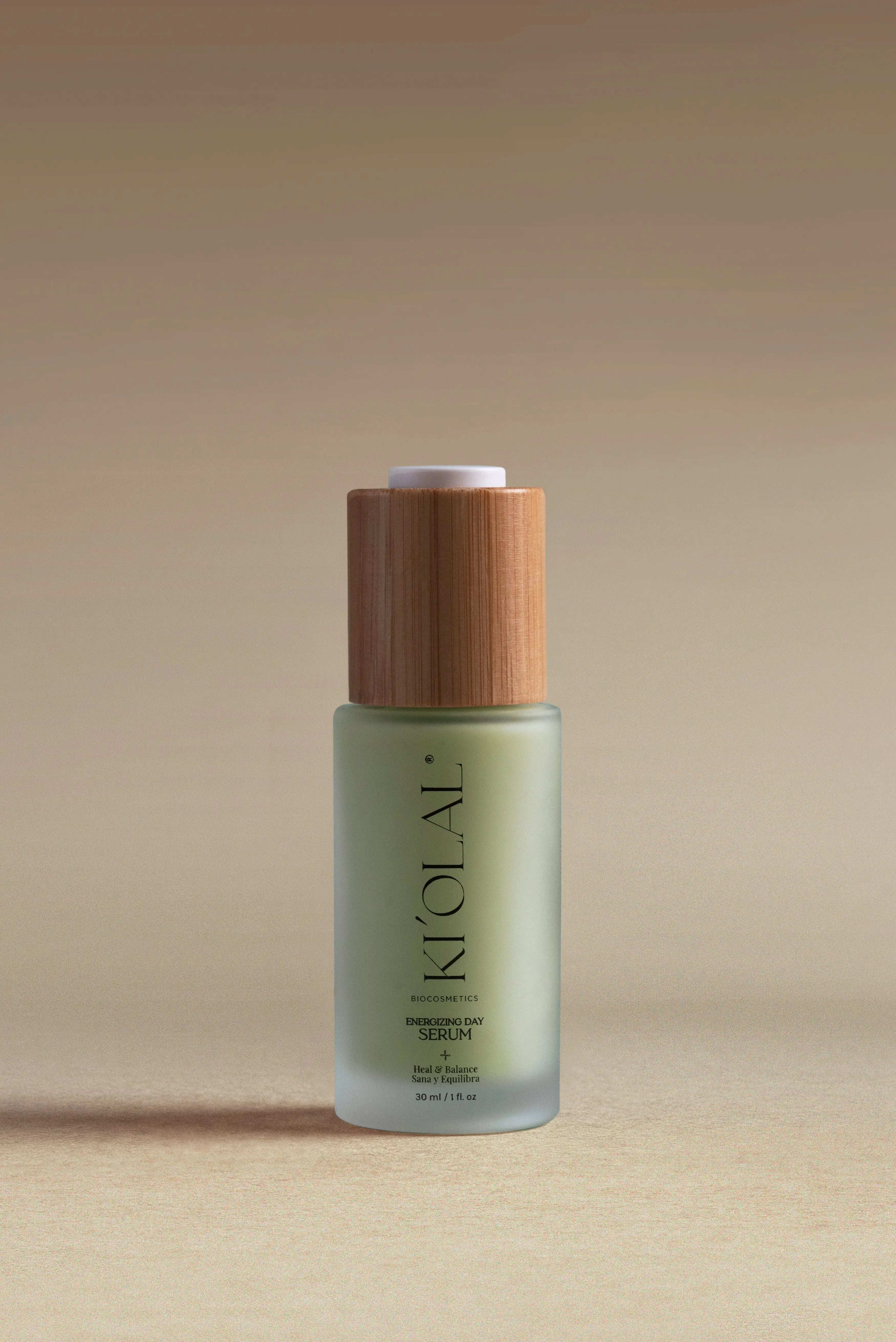 KI'OLAL Energizing Day Serum in green glass bottle with bamboo cap on neutral backdrop