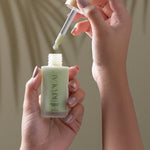 Hand holding KI'OLAL Day Serum bottle with dropper