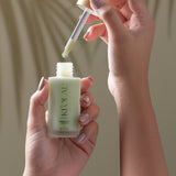 Hand holding KI'OLAL Day Serum bottle with dropper