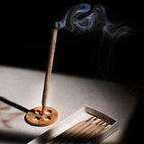 Burning KI'OLAL incense stick with smoke, minimalist tranquility aesthetic
