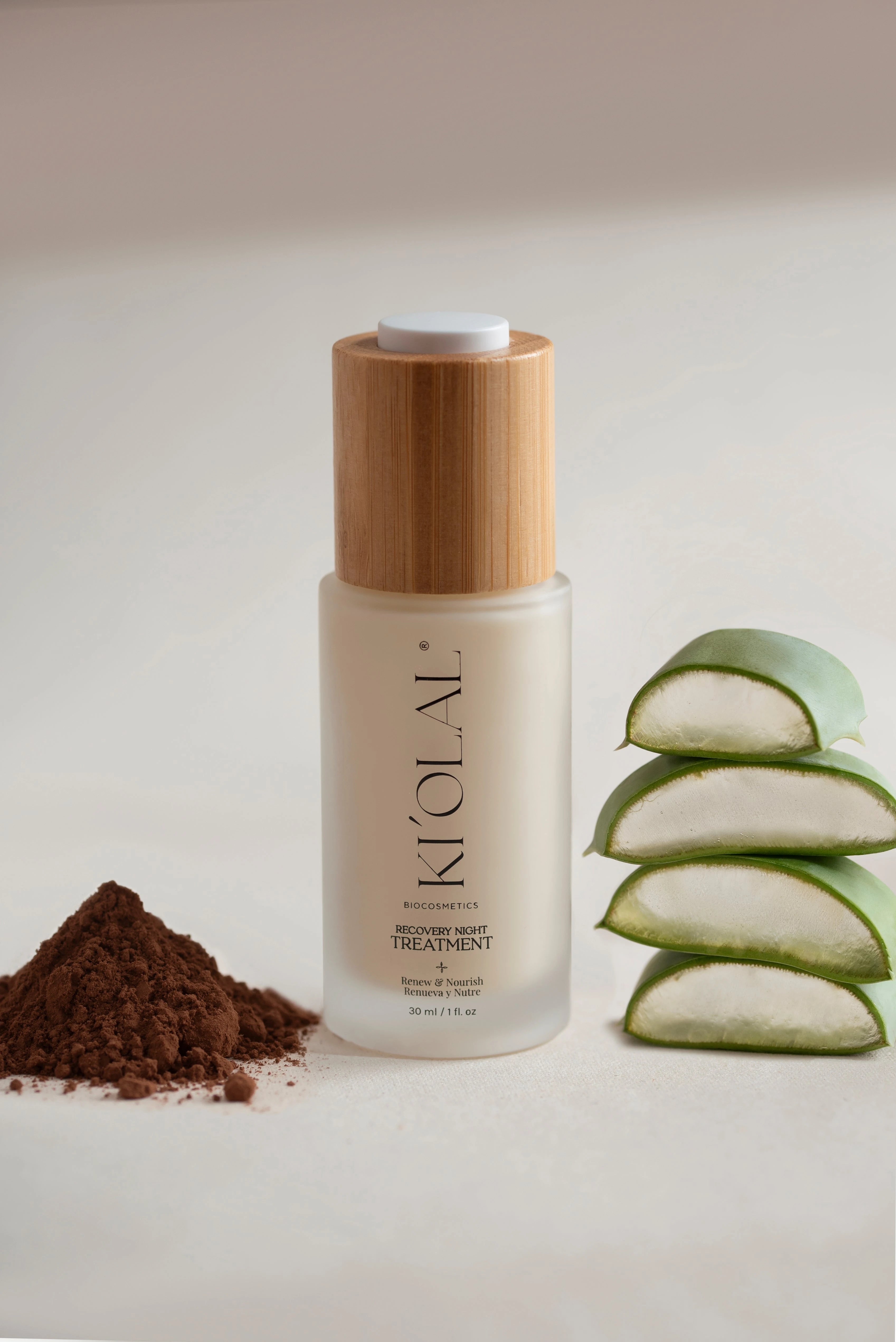 Recovery Night Treatment bottle from KI'OLAL, styled with aloe slices and cacao to reflect natural formulation.